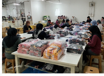 Tim menyortir dan melipat stok baju anak grosir